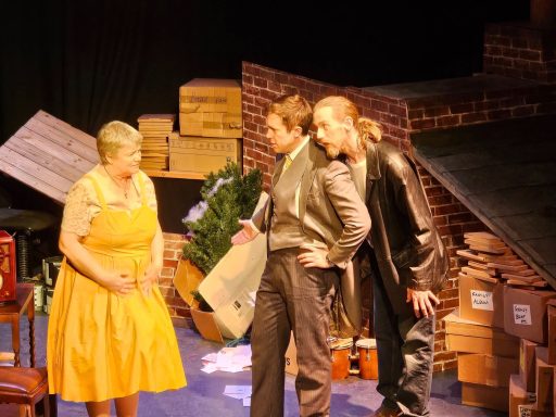Woman in yellow dress looking at two men who look expectantly at her.